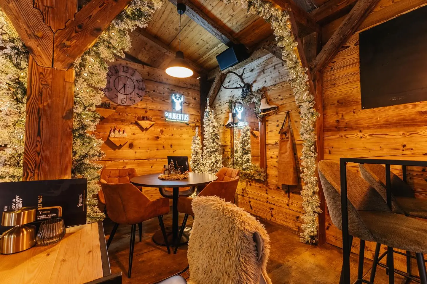 Het interieur van Chalet 9620: warm hout, lampen, kerstbomen met lichtjes en stoelen met schapenvacht